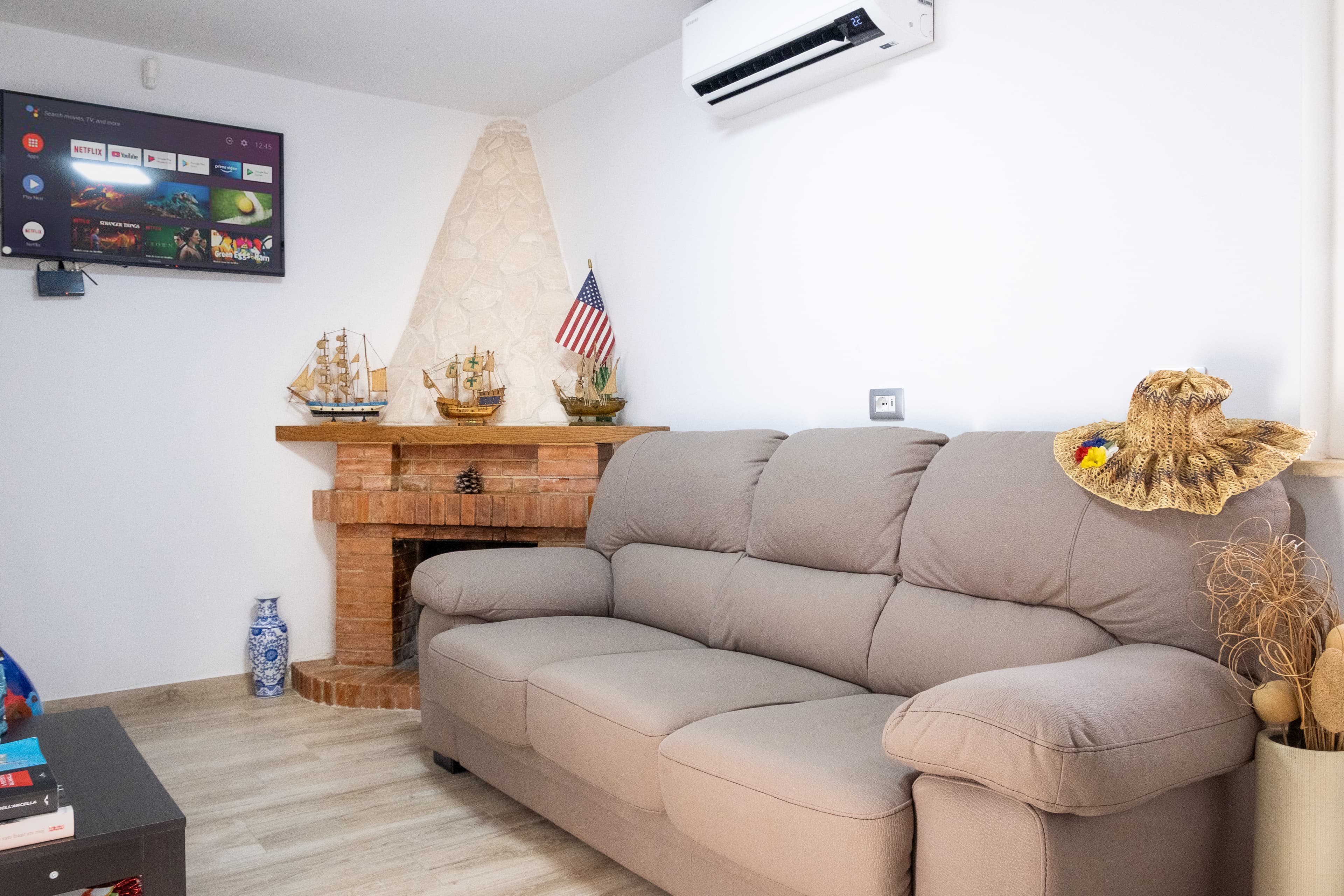 Salotto con camino — Un ambiente accogliente con divano, camino rustico e TV a parete